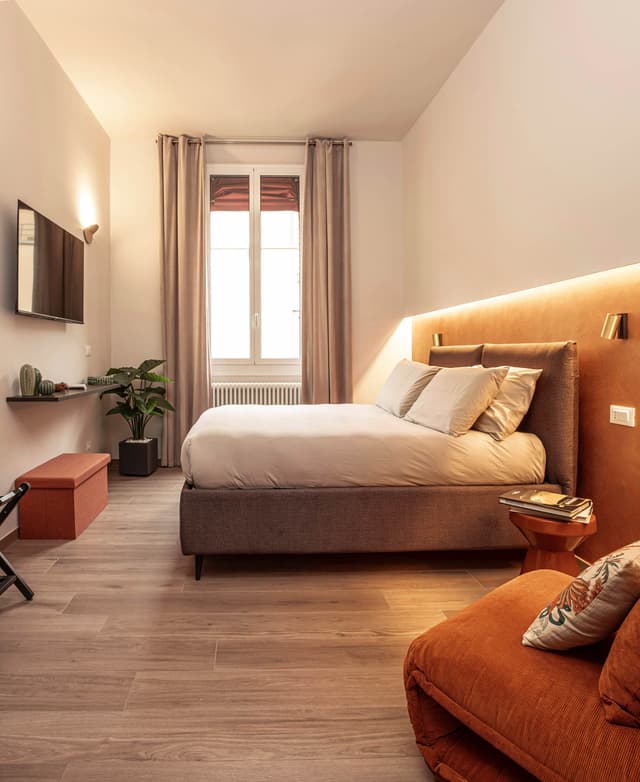 Master bedroom 'Piazza Grande' con letto queen size e poltrona letto, televisione e bagno privato